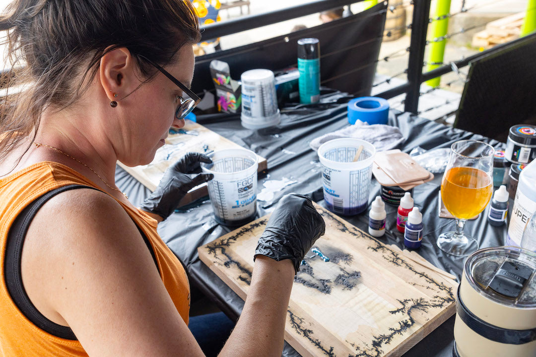 A student filling their fractal board with epoxy
